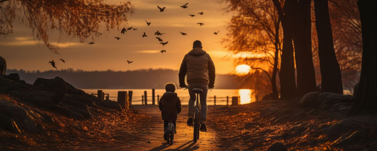 Rear view of a boy riding a bicycle with his father next to him. Photo by Keitma | stock.adobe.com  

